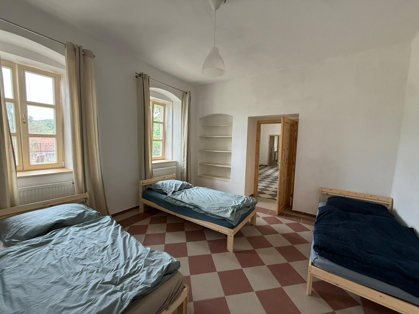 Pokoj se třemi samostatnými lůžky a historickou dlažbou