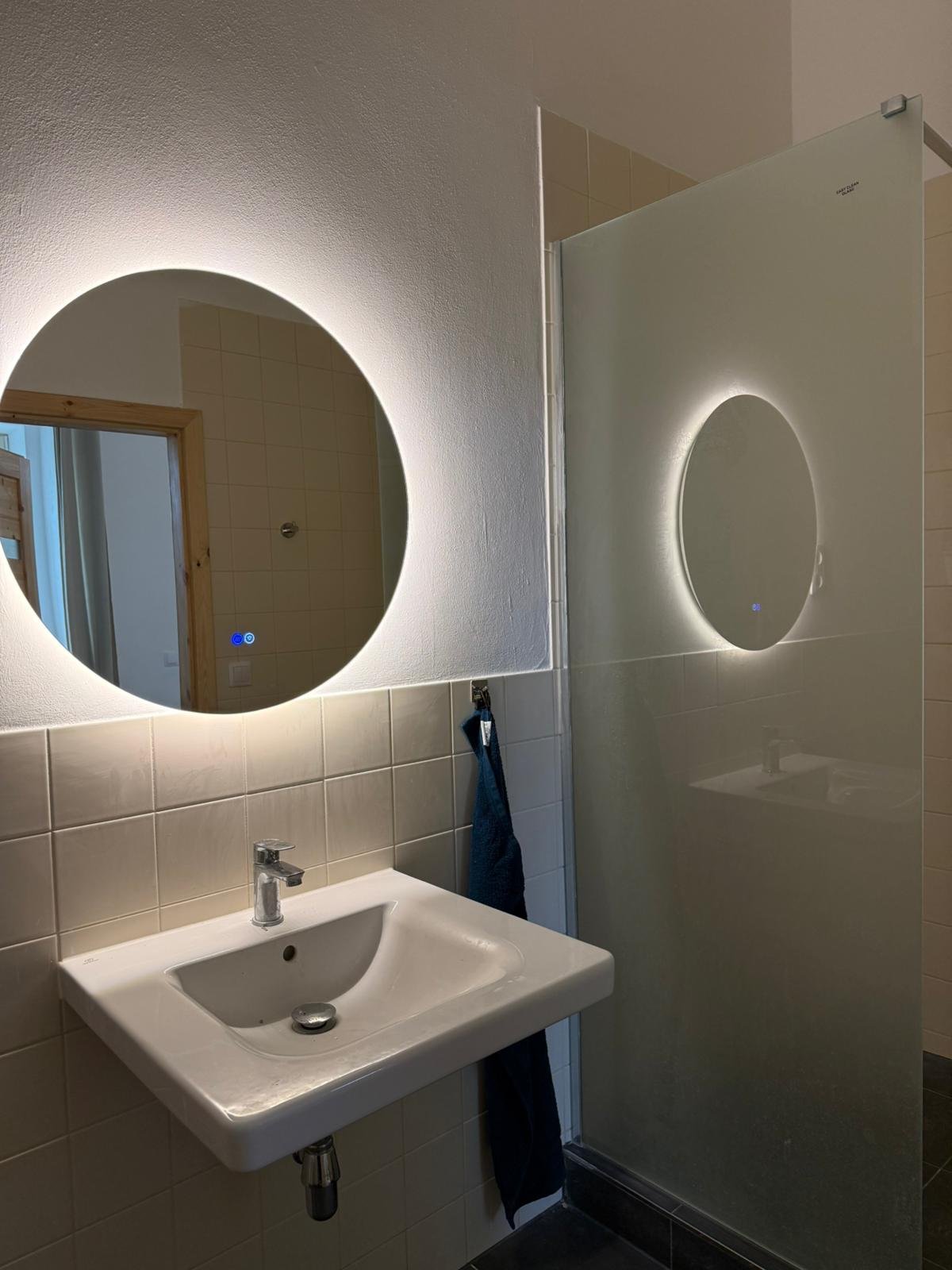 Koupelna apartmánu 2 s podsvíceným zrcadlem a sprchou