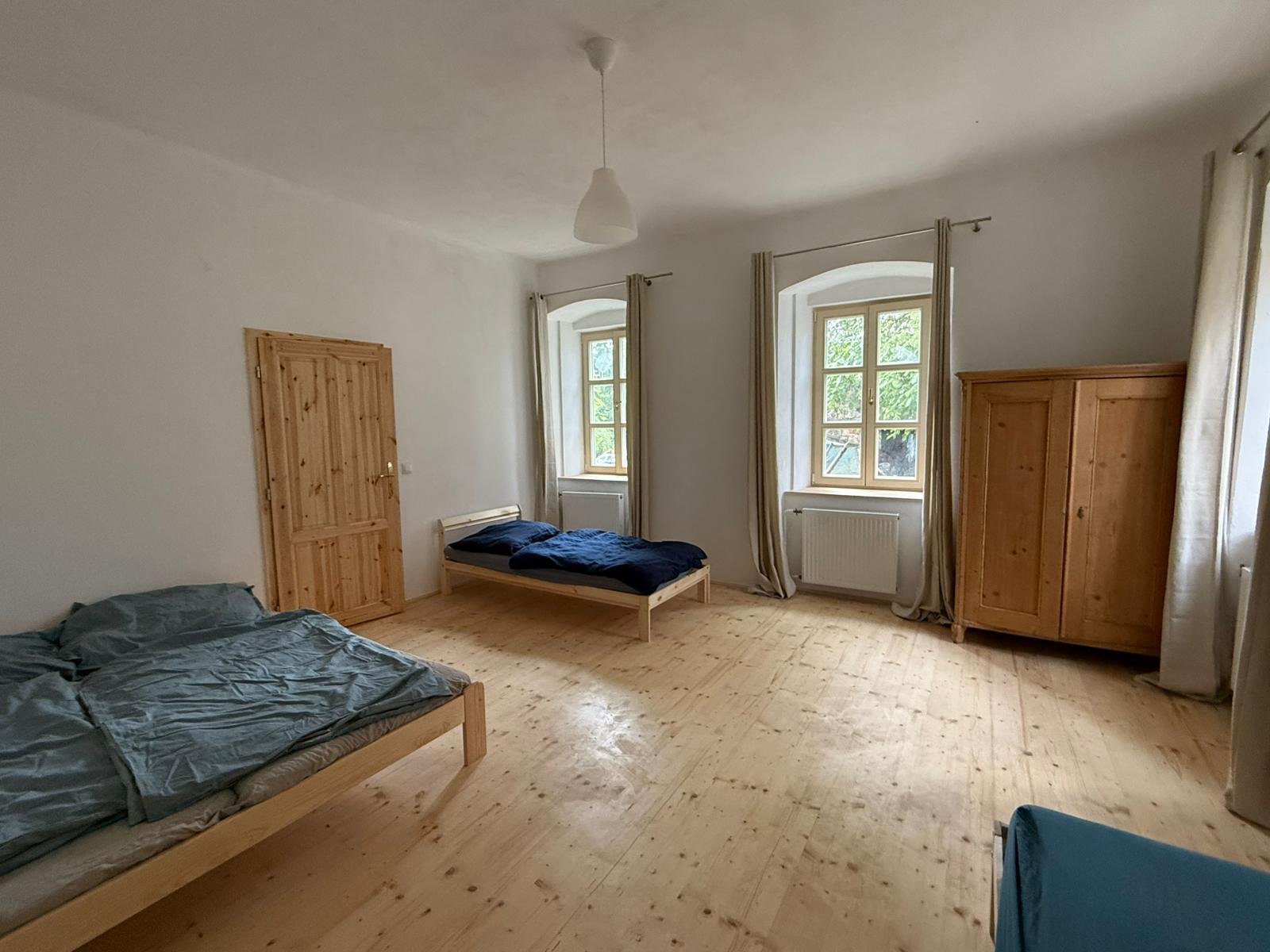 Prostorný pokoj apartmánu 2 s postelemi a starožitnou skříní
